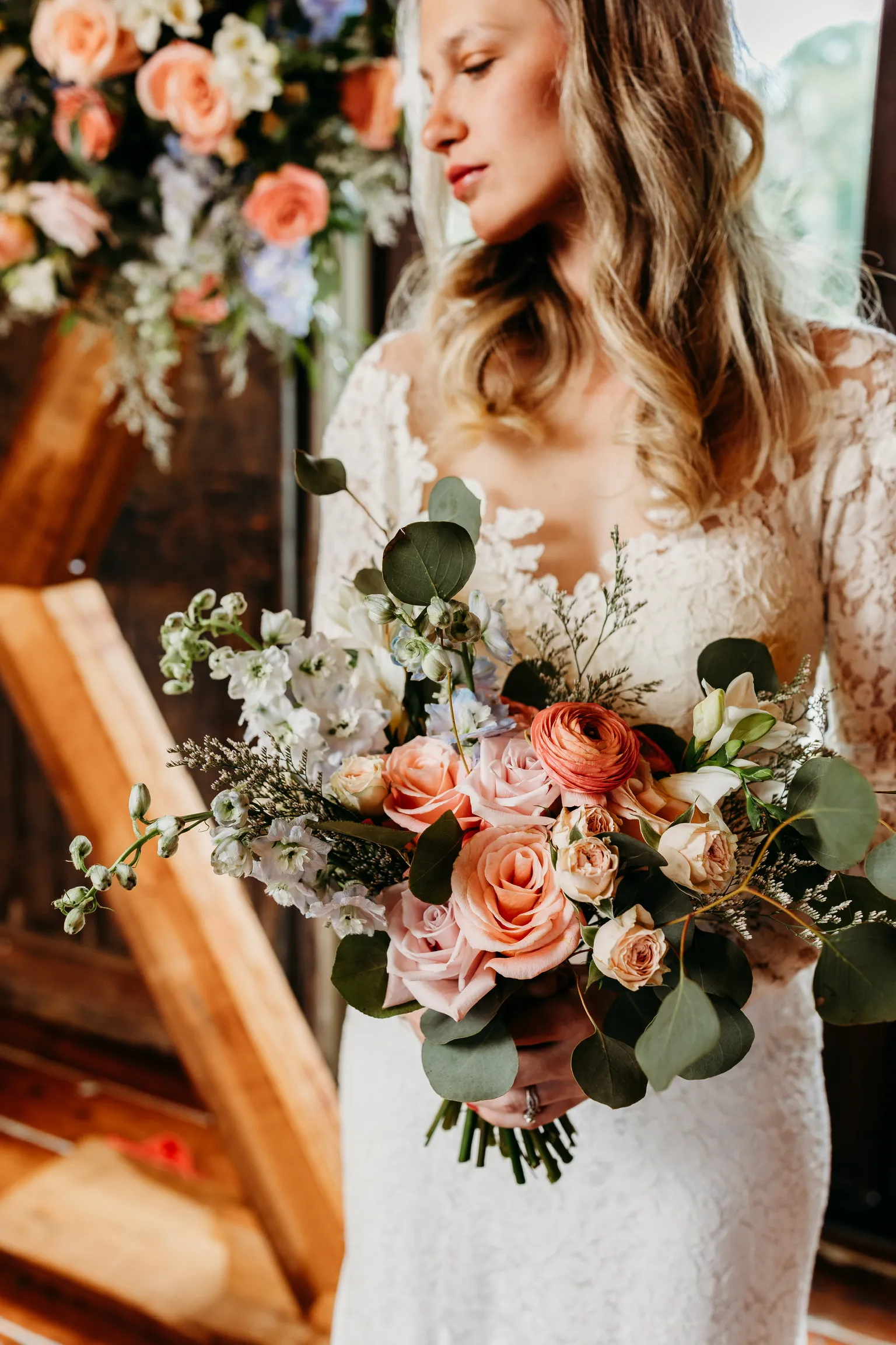 Bride holding a blush bouquet by Heather Florals